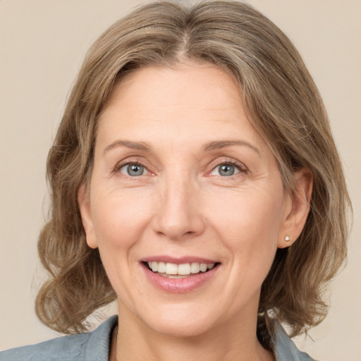 Joyful white adult female with medium  brown hair and grey eyes