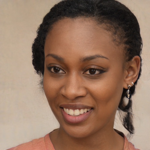 Joyful black young-adult female with long  black hair and brown eyes