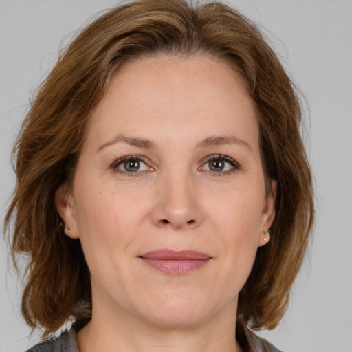 Joyful white adult female with medium  brown hair and green eyes