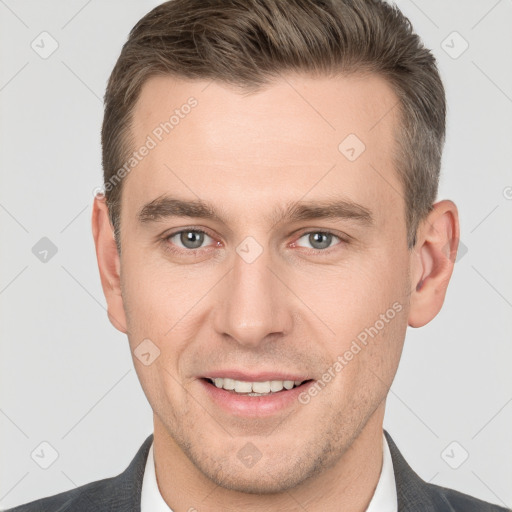 Joyful white young-adult male with short  brown hair and grey eyes