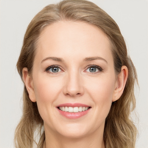 Joyful white young-adult female with long  brown hair and blue eyes