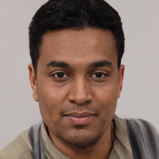 Joyful latino young-adult male with short  black hair and brown eyes