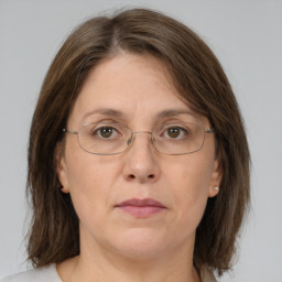 Joyful white adult female with medium  brown hair and green eyes