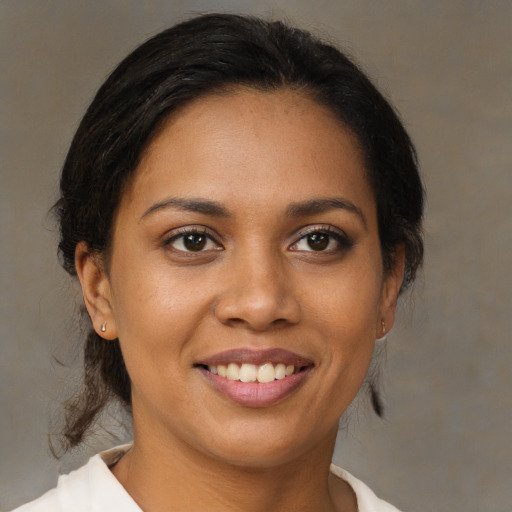 Joyful black young-adult female with medium  brown hair and brown eyes