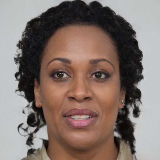 Joyful black adult female with long  brown hair and brown eyes
