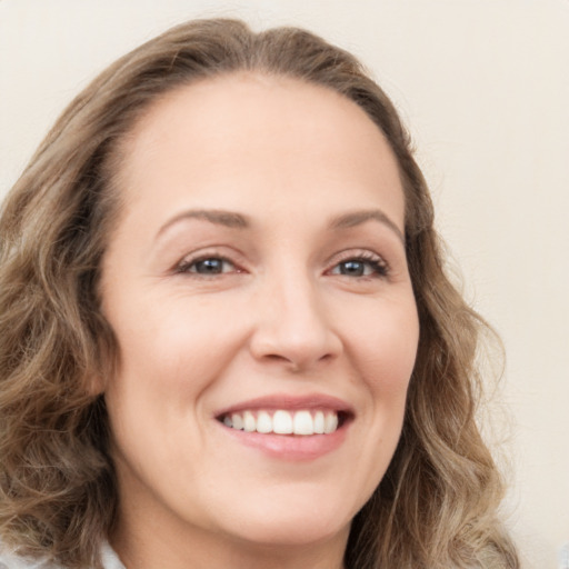 Joyful white young-adult female with long  brown hair and green eyes