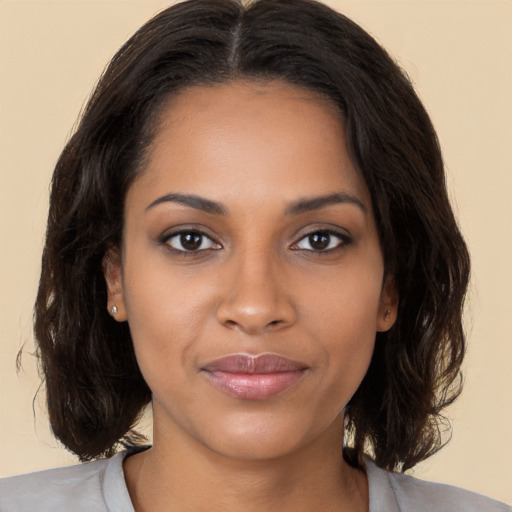 Joyful black young-adult female with medium  brown hair and brown eyes