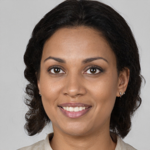 Joyful black young-adult female with medium  brown hair and brown eyes