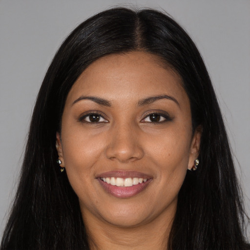 Joyful black young-adult female with long  brown hair and brown eyes
