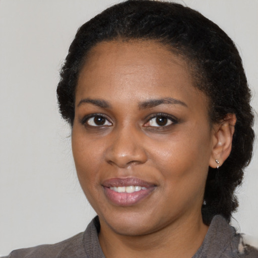 Joyful black young-adult female with medium  black hair and brown eyes