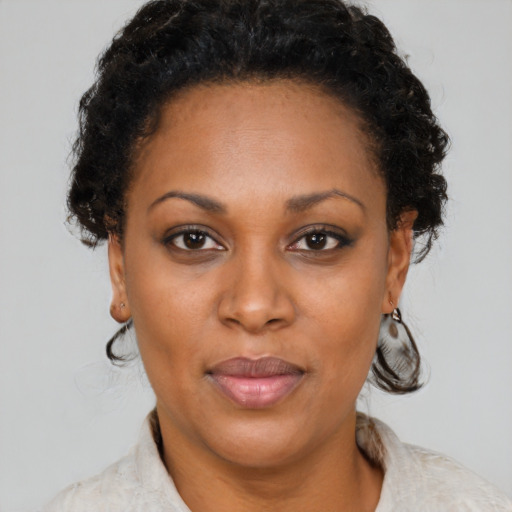 Joyful black adult female with short  brown hair and brown eyes