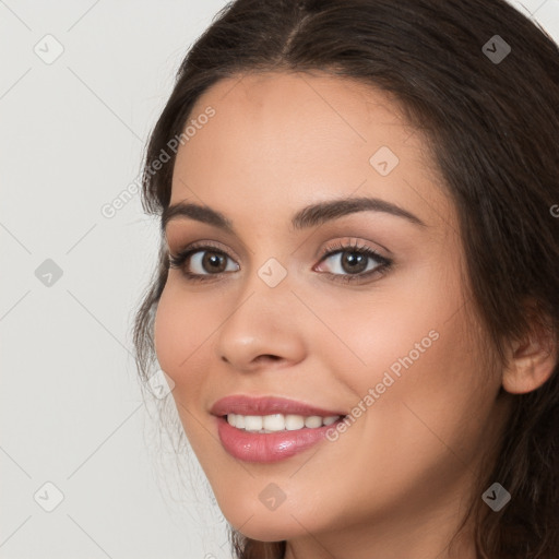 Joyful white young-adult female with long  brown hair and brown eyes