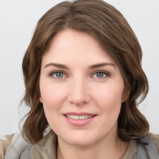 Joyful white young-adult female with medium  brown hair and grey eyes