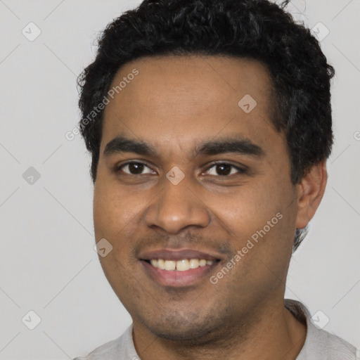 Joyful black young-adult male with short  black hair and brown eyes