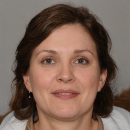 Joyful white adult female with medium  brown hair and blue eyes