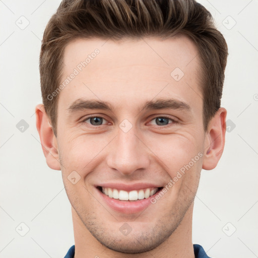 Joyful white young-adult male with short  brown hair and grey eyes