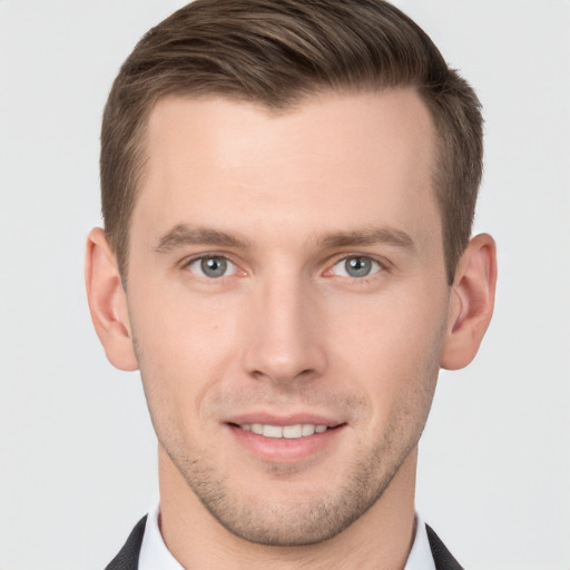 Joyful white young-adult male with short  brown hair and grey eyes