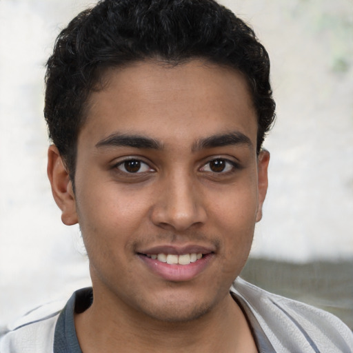 Joyful latino young-adult male with short  brown hair and brown eyes