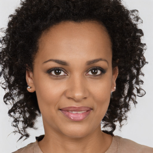 Joyful black young-adult female with long  brown hair and brown eyes