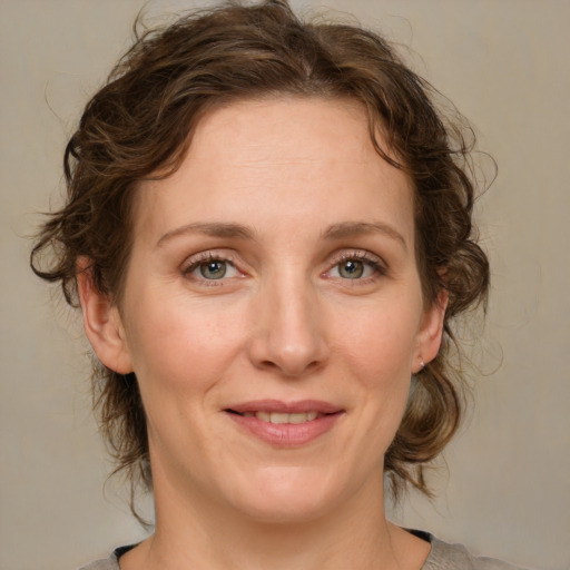 Joyful white adult female with medium  brown hair and green eyes