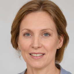 Joyful white adult female with medium  brown hair and grey eyes