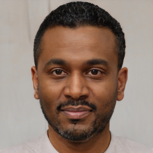 Joyful black young-adult male with short  black hair and brown eyes
