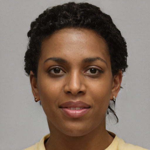 Joyful black young-adult female with short  black hair and brown eyes