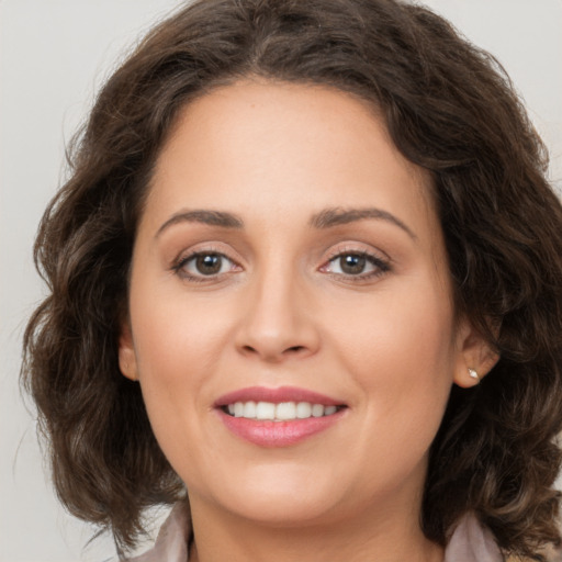 Joyful white young-adult female with long  brown hair and green eyes