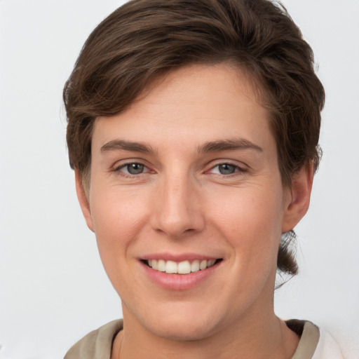 Joyful white young-adult female with short  brown hair and grey eyes