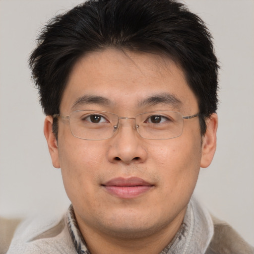 Joyful asian adult male with short  brown hair and brown eyes