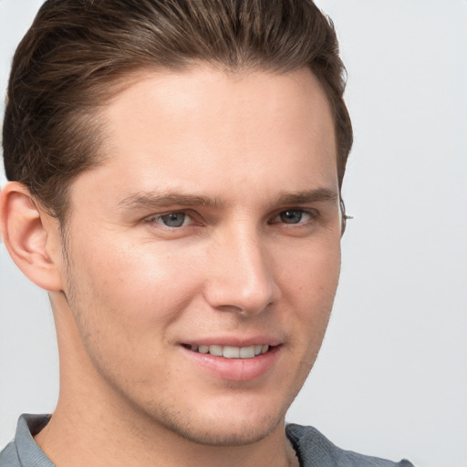 Joyful white young-adult male with short  brown hair and grey eyes