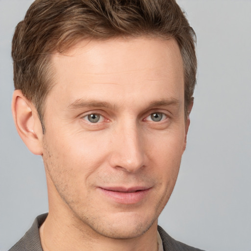 Joyful white young-adult male with short  brown hair and grey eyes