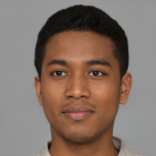 Joyful black young-adult male with short  black hair and brown eyes