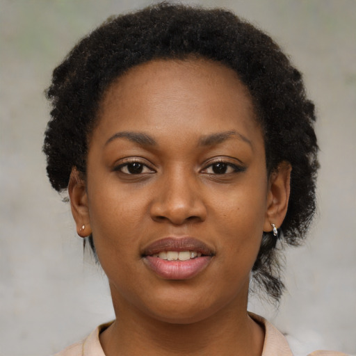 Joyful black young-adult female with short  black hair and brown eyes