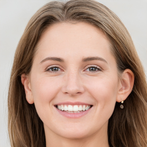 Joyful white young-adult female with long  brown hair and brown eyes