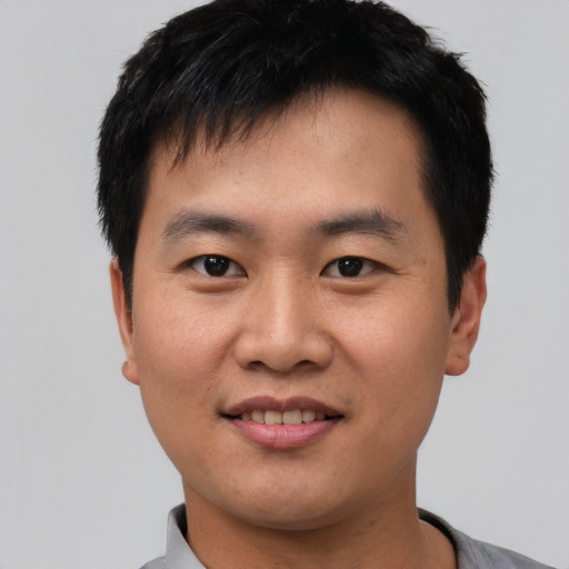 Joyful asian young-adult male with short  black hair and brown eyes