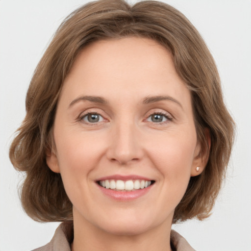 Joyful white young-adult female with medium  brown hair and green eyes