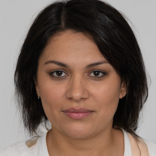 Joyful latino young-adult female with medium  brown hair and brown eyes