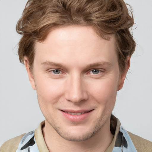 Joyful white young-adult male with short  brown hair and blue eyes