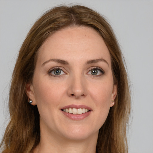 Joyful white young-adult female with long  brown hair and grey eyes