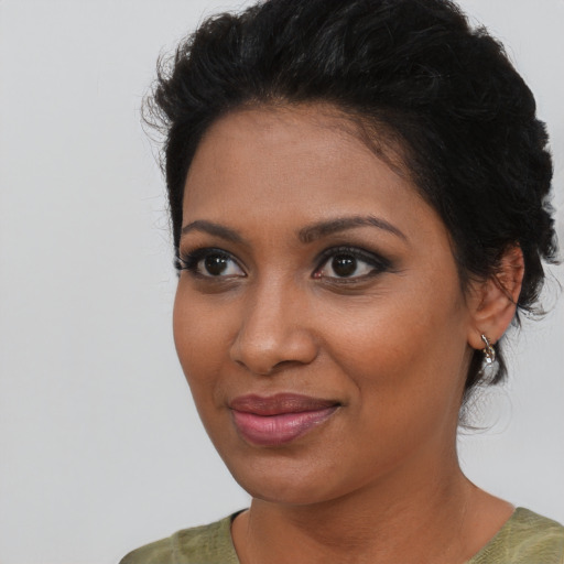 Joyful black young-adult female with medium  brown hair and brown eyes