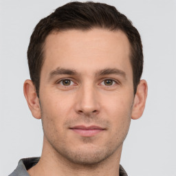 Joyful white young-adult male with short  brown hair and grey eyes