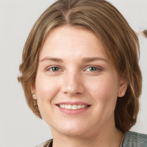 Joyful white young-adult female with medium  brown hair and green eyes