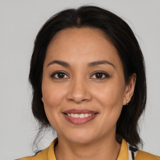 Joyful latino adult female with medium  brown hair and brown eyes