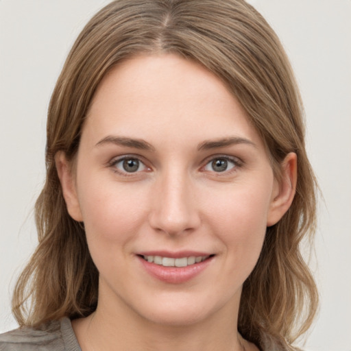 Joyful white young-adult female with medium  brown hair and grey eyes