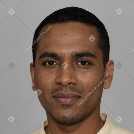 Joyful black young-adult male with short  black hair and brown eyes