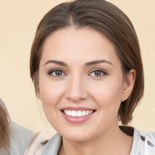 Joyful white young-adult female with medium  brown hair and brown eyes