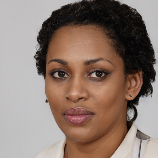 Joyful black young-adult female with medium  black hair and brown eyes