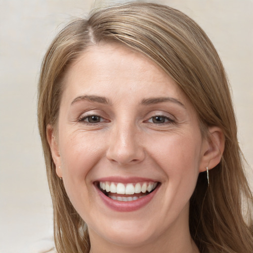 Joyful white young-adult female with long  brown hair and grey eyes