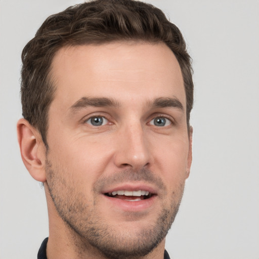 Joyful white young-adult male with short  brown hair and grey eyes